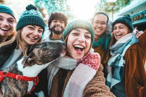 Happy friends group wearing winter clothes taking selfie walking on city street